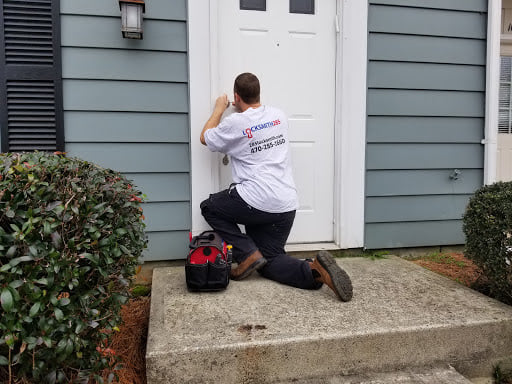 A 285 Locksmith technician kneeling to work on a front door lock